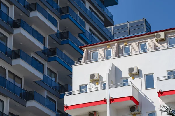 Güneşle aydınlatılan eski beyaz bir bina gölgede yeni bir gökdelenin arka planında..