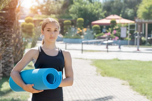 Młoda Dziewczyna Trzyma Rękach Matę Fitness Ćwiczenia Zewnętrzne — Zdjęcie stockowe