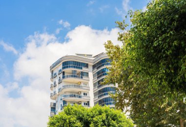 Exterior of a high-rise apartment building. Large balconies. Sunny day. Residential Properties.