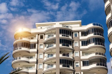 Exterior of a modern apartment building against a blue sky with clouds. Residential Properties.