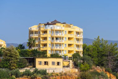 Residential multi-family yellow house surrounded by greenery. Residential Properties.