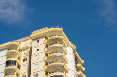 Exterior of a modern apartment building against a blue sky with clouds. Residential Properties.