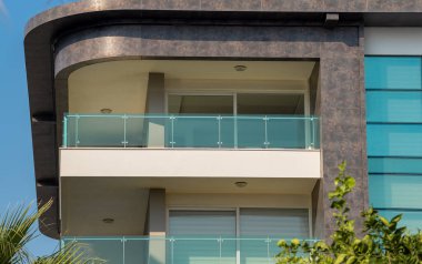 New apartment building with large balconies with glass railings. Modern architecture near the sea coast.