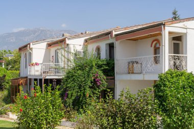 Dağlı mavi gökyüzüne karşı alçak beyaz evler. Güneşli bir gün.