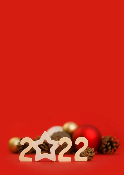 Verticale Kerstkaart Met 2022 Nummers Nieuwjaarsballen Dennenappels Een Rode Achtergrond — Stockfoto