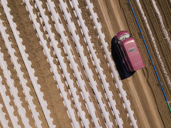 Kapací zavlažovací skleníkové systémy na zemědělském poli s farma van zavazadlový vůz. Letecký výstřel shora dolů. Rusko. — Stock fotografie
