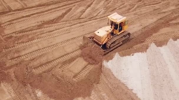 Gula grävmaskin eller bulldozer fungerar på byggarbetsplatsen med sand-, antenn-eller övre — Stockvideo