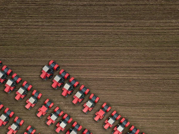 Tracteurs rouges sur les terres agricoles. Plan aérien du haut vers le bas. — Photo