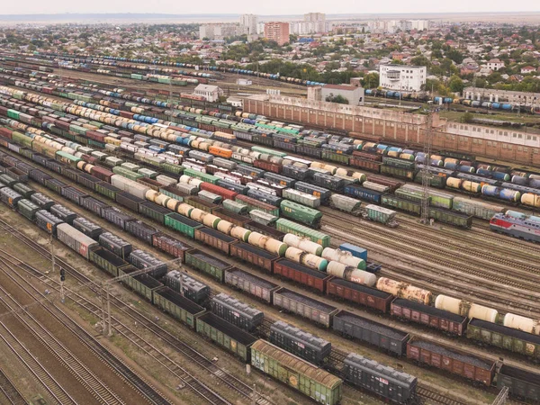 Kargo trenleri yakın plan. Tren istasyonundaki renkli yük trenlerinin hava manzarası. Demiryolunda malları olan vagonlar. Ağır endüstri. Trenli endüstriyel kavramsal sahne. Uçan İHA 'nın üst görüntüsü