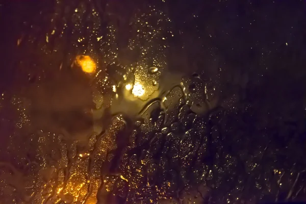 Рейн на стекле ночью — стоковое фото