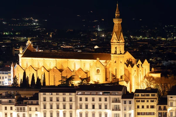 Ночной панорамный вид на средневековую базилику Святого Креста, освещенные здания вдоль реки Арно и городские огни на заднем плане. Флоренция, Тоскана, 12 января 2022 года — стоковое фото