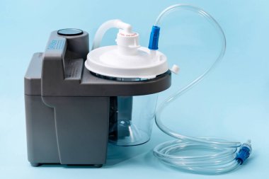 Milan, İtalya - 01.04.2020: Mavi arka planda tıbbi emme makinesi. Sümük, kan ve hastadan vücut sıvılarını almak için kullanılan taşınabilir aspiratör. Ambulanslarda tıbbi ekipman kullanılıyor