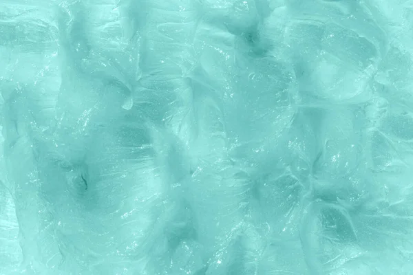 Creamy balm texture product closeup. Mint cosmetic smear background. Moisturising and cleaning beauty product sample