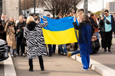 Milan, 24 Şubat 2022. İnsanlar Rusya 'nın Ukrayna' ya saldırmasını ve Putin hükümetine saldırmasını protesto ediyor. İki kadın Ukrayna bayrağını vatanseverlik sembolü olarak taşıyor