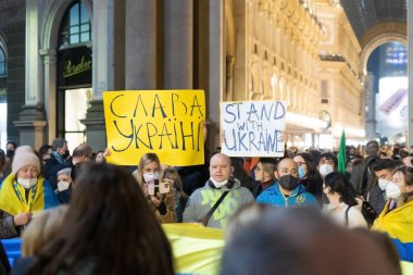 Milan, 24 Şubat 2022. Afişleri ve sloganları olan insanlar Ukrayna 'nın Ukrayna ve Zaferi ile birlikte Ukrayna' ya yapılan Rus işgaline karşı fikirlerini gösteriyorlar. Meydan Piazza della Scala 'da toplantı