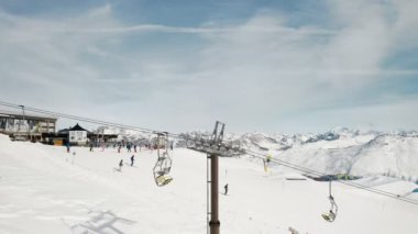 Livigno, İtalya - 21 Şubat 2022: Lombardy, İtalya 'daki Livigno kayak merkezinin havadan görünüşü. Sandalyeler, kayak asansörleri, teleferik hareket halindeki kabinler ve manzara üzerinde kayak yapan kayakçılar. 4k video kaydı 