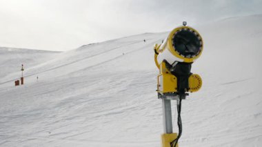 Livigno, İtalya - 21 Şubat 2022: Kar makinesi, kayak merkezi Livigno, İtalya 'da güneşli kış günlerinde kar topu ve arka planda kayakçılar. 4k görüntü videosu