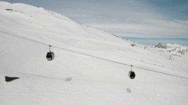 Livigno, İtalya - 21 Şubat 2022: Lombardy, İtalya 'daki Livigno kayak merkezinin havadan görünüşü. Sandalyeler, yukarı aşağı giden kayak asansörleri, arka planda kayak yapan kayakçılar. 4k video kaydı 
