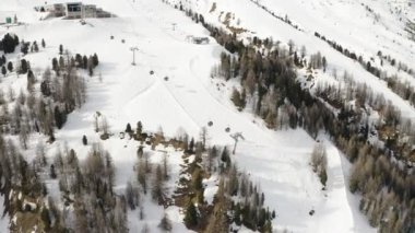 Livigno, İtalya - 21 Şubat 2022: Lombardy, İtalya 'daki Livigno kayak merkezinin havadan görünüşü. Sandalyeler, kayak asansörleri, teleferik hareket halindeki kabinler ve manzara üzerinde kayak yapan kayakçılar. 4k video kaydı 