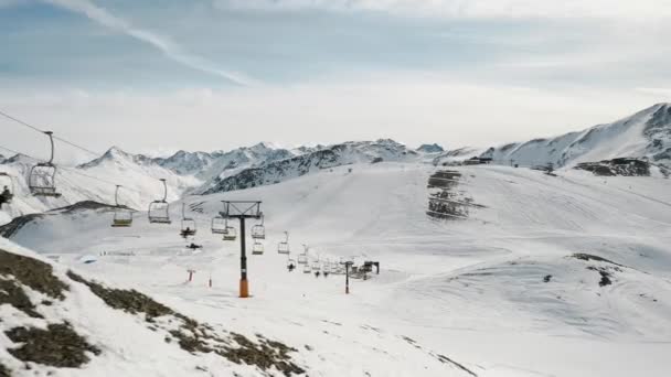 Livigno, Italië - 21 februari 2022: vanuit de lucht uitzicht op het skigebied Livigno in Lombardije, Italië. Stoelen liften, skiliften, gondelbaan cabine verplaatsen en skiërs skiën over het landschap panorama. 4k videobeelden — Stockvideo