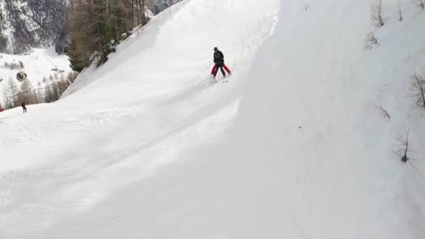 Livigno, Itália - 21 de fevereiro de 2022: vista aérea da estância de esqui de Livigno, na Lombardia, Itália. Cabana de gôndola em movimento, esquiador aprendendo a esquiar com instrutor. Aula de esqui na escola alpina. Imagens de vídeo 4k — Vídeo de Stock