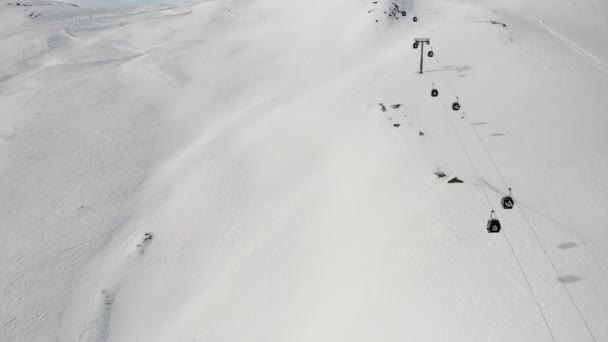 Livigno, Italië - 21 februari 2022: vanuit de lucht uitzicht op het skigebied Livigno in Lombardije, Italië. Stoeltjesliften, skiliften die op en neer gaan, skiërs die op de achtergrond skiën. 4k videobeelden — Stockvideo