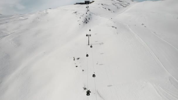 Livigno, Italia - 21 de febrero de 2022: vista aérea de la estación de esquí de Livigno en Lombardía, Italia. Telesillas, telesillas subiendo y bajando, esquiadores esquiando al fondo. Imágenes de vídeo 4k — Vídeos de Stock