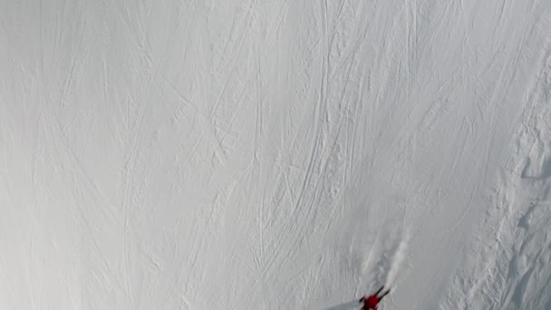 Livigno, Italia - 21 de febrero de 2022: Personas esquiando snowboard en la estación de esquí. Esquiadores, snowboarders montando nieve en la ladera de la montaña. Deportes de invierno al aire libre. Imágenes aéreas, vista superior, vídeo 4k — Vídeo de stock