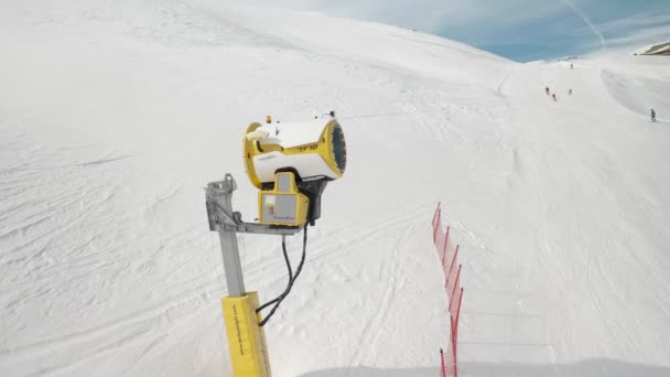 Livigno, Italien - 21 februari 2022: Snö gör maskin, snö kanon på skidorten Livigno, Italien på snöig vinterdag och skidåkare på bakgrunden. Videofilmer med 4k — Stockvideo
