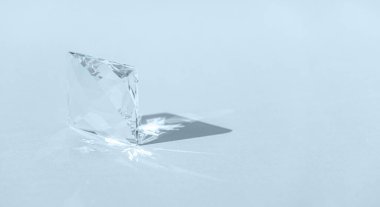 Spektrum renklerinin ışık kırılması ve modaya uygun ışık ve mavi arka planda sert gölgelerle yansıması olan kristal prizma. Cam prizmasından yansıyan ışık tayfı