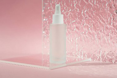 Hyaluronik asit yağı, kolajen ve peptid içeren serum arka planda akrilik kaburga plakalı cilt bakımı ürünü. Şeffaf şişede kozmetik sıvısı modeli.