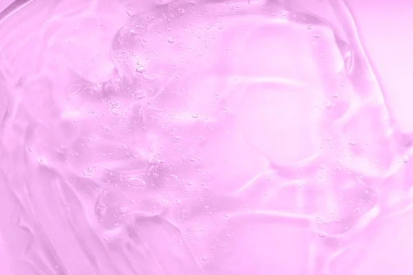Loción para el cuidado de la piel cara muestra de suero. Fondo manchado de gel rosa. Ácido hialurónico para el cuidado de la piel con colágeno y retinol. Crema cosmética gel líquido transparente. —  Fotos de Stock