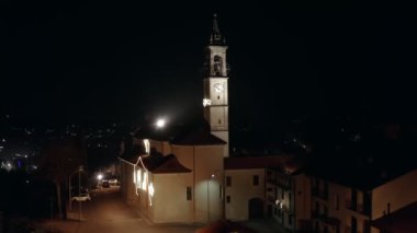 Güzel bir gece helikopteri. 4k aydınlanmış ortaçağ kilisesinin çan kulesiyle çekilmiş görüntüleri. 
