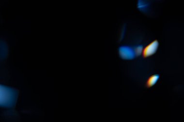 Mavi ışık prizması gökkuşağı parlamaları siyah arka plan, ışık geçişi kristalleri, prizmatik güneş yakalayıcı ışınları üzerinde etkiye sahiptir. Soyut bulanık renkli lensler koyu renk üzerinde parlıyor.