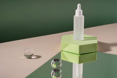 Hyaluronik asit kozmetik ürünleri şık malzemelerle paketleme yapıyor. Yeşil arka planda podyum kaidesi üzerinde peptit ve retinol içeren serum kozmetik şişesi. Serum güzellik düşürücü model