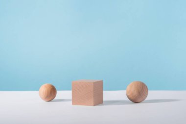 Kozmetik ya da mücevher gösterisi için mavi arka planda küresi olan tahta küp podyumu. Yaratıcı geometrik ürün sahnesi modelleme, kozmetik ekran platformu, ürün reklamcılığı