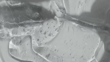 Şeffaf jel serumu dokusu görüntü yayıyor. Kabarcıklı Hyaluronik asit. Sıvı kozmetik cilt toneri peptit ve kolajenle güzellik ürünü. Temizleyici arkaplan videosu 4k. 