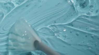 Kabarcık görüntülü Hyaluronik asit jel dokusu. Sıvı kozmetik cilt mavi losyon toner peptit ve kolajenle güzellik ürünü. Turkuaz temizleyici arka plan videosu 4k. 