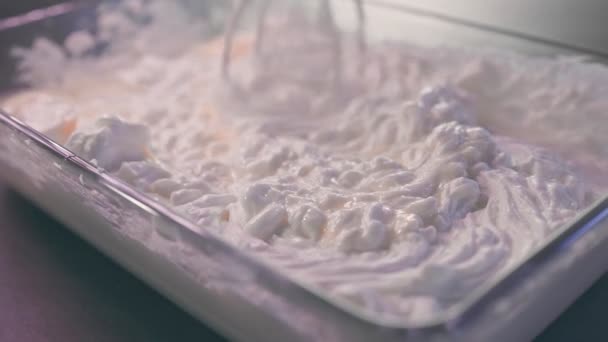 Peynirli kek görüntülerini hazırlamak için mascarpone peyniri ile yumurtaları karıştırıyorum. Peynirli yumurta çırpmak. Cheesecake pişirme süreci video 4k. — Stok video