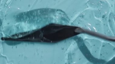 Kabarcık görüntülü şeffaf hiyalüronik asit jel dokusu. Kozmetik cilt turkuaz losyon tonik peptit ve kolajenle güzellik ürünü. Mavi temizleyici arkaplan videosu 4k