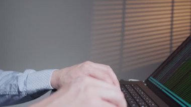 Programcı yazma uygulamasının yan görüntüsü. IT geliştiricisi dizüstü bilgisayarla çalışıyor. Erkek uzman yazılım mühendisi geliştiriyor. Kodlama dili olan uçbirim. 