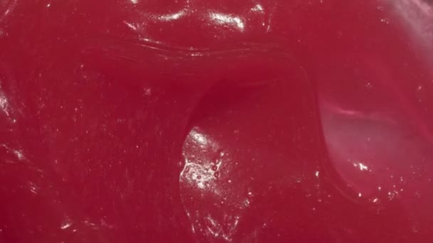 Tooth paste texture spreading by spatula footage. Red abstract wax cream cosmetic background video. Pink sticky balm, sweet toothpaste — Stock Video