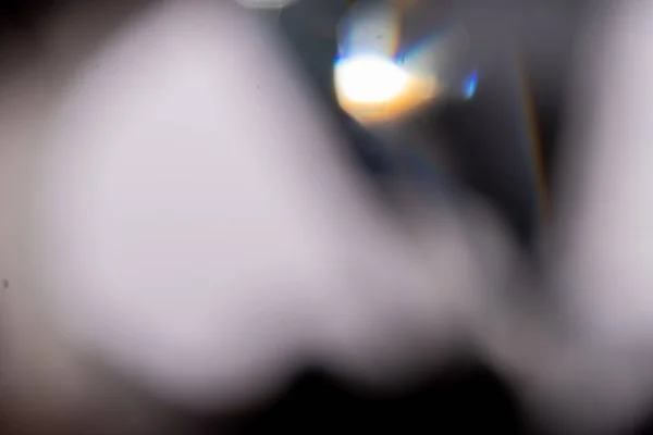Azzurro chiaro bagliore prisma razzi arcobaleno effetto sovrapposizione su sfondo nero, cristalli incrociati di luce, prismatico sole catcher riflessi raggi. Lente sfocata astratta colorata brillamento bokeh sul buio — Foto Stock