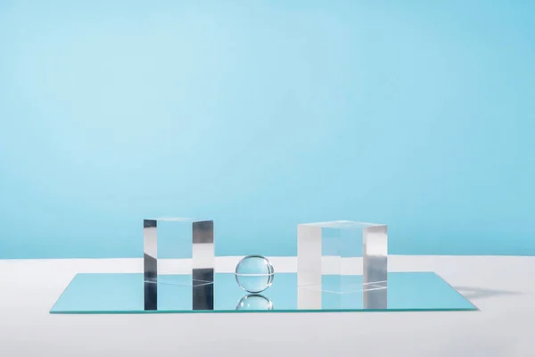 Plataforma de podio de cristal de exhibición cosmética pedestal con accesorios elegantes para la presentación del producto, soporte geométrico de cosméticos, escena de maqueta para joyas. Bloques de acrílico cubos y espejo en azul — Foto de Stock