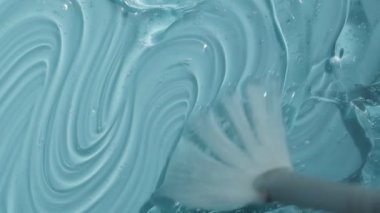 Hyaluronik asit dokusu ve kabarcık görüntüsü. Sıvı kozmetik cilt, peptit ve kolajenle mavi toner güzellik ürünü. Turkuaz temizleyici arka plan videosu 4k. 
