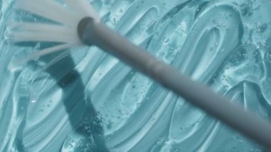 Turkuaz temizleyici soyut arkaplan videosu 4k. Şeffaf hyaluronik asit jel doku görüntüsü. Sıvı kozmetik cilt mavi losyon toner peptit ve kolajen içeren güzellik ürünü