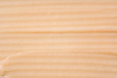 Saç kremi arka planı. Sarı kozmetik losyon nemlendirici numunesi yakın çekim. Vücut bakım kremi, retinol serumu, şampuan dalgalı doku. Cilt maskesi lekesi, kremalı temizleyici.