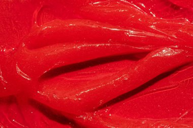 Kırmızı jel dokusu. Kozmetik temiz sıvı krem lekesi. Cilt bakım ürünleri numunesi yakın çekim. Diş macunu ya da balmumu