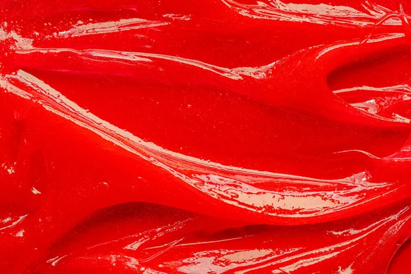 Red gel texture. Cosmetic clear liquid cream smudge. Skin care product sample closeup. Toothpaste or wax — Stockfoto