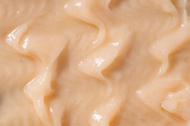 Vücut bakım kremi, retinol serumu, şampuan dalgalı doku. Saç kremi arka planı. Sarı kozmetik losyon nemlendirici numunesi yakın çekim. Cilt maskesi lekesi, kremalı temizleyici.